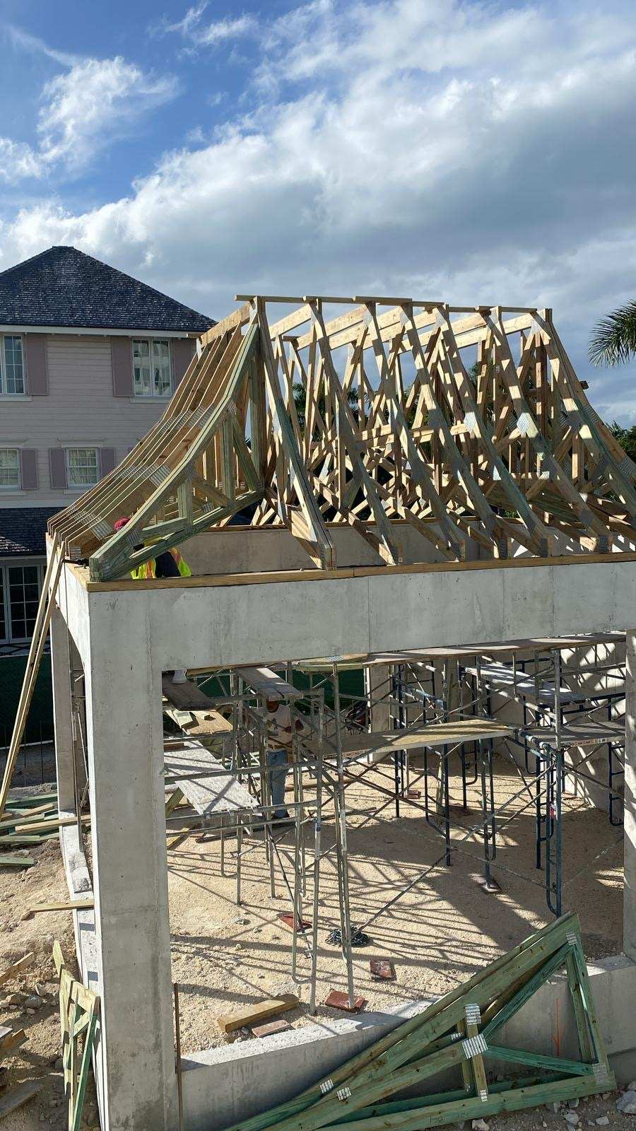 Timber roof trusses set on a poured concrete structure.