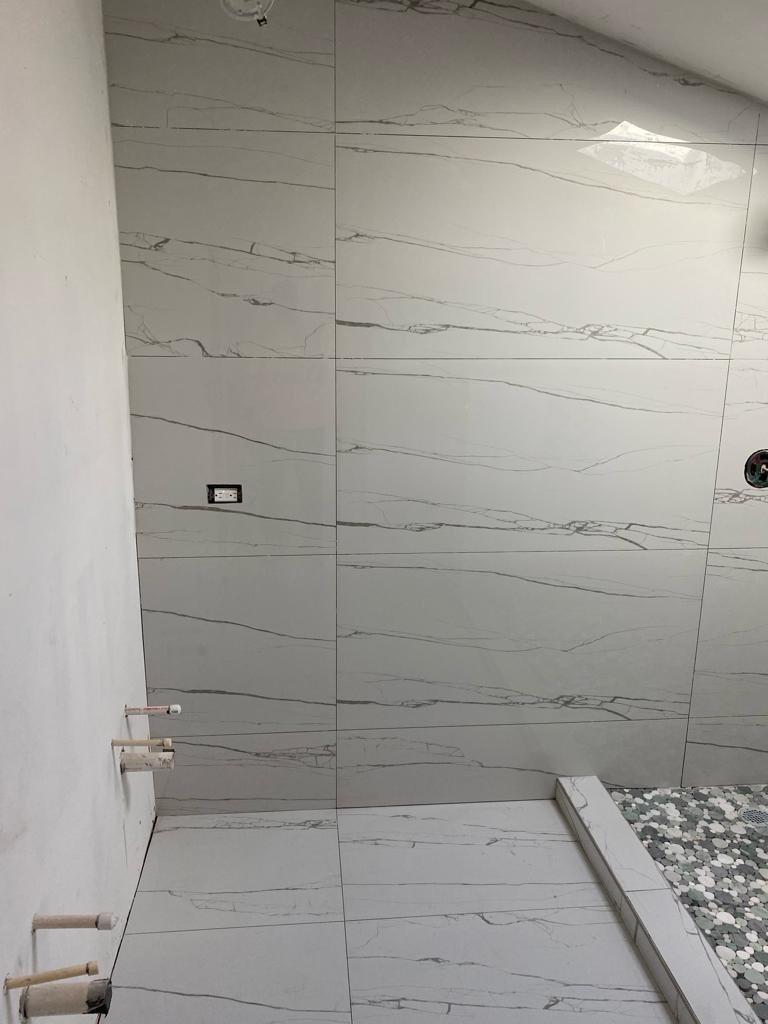 Large format marble wall tile set with tight even joints.