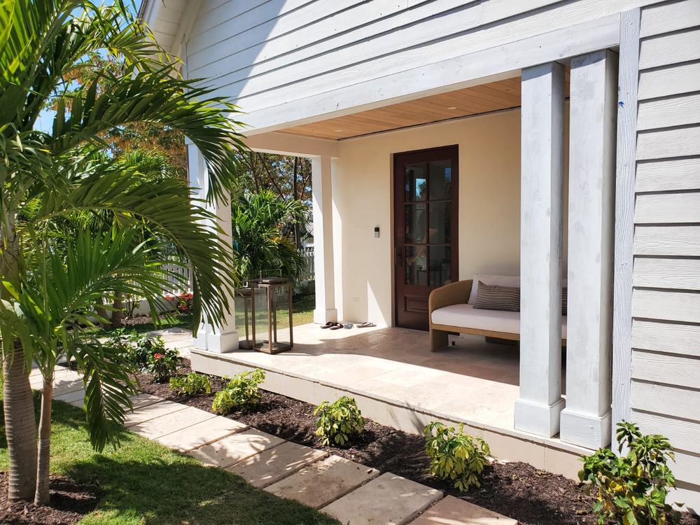 Covered front entry with hardwood ceiling, stone path and planting.