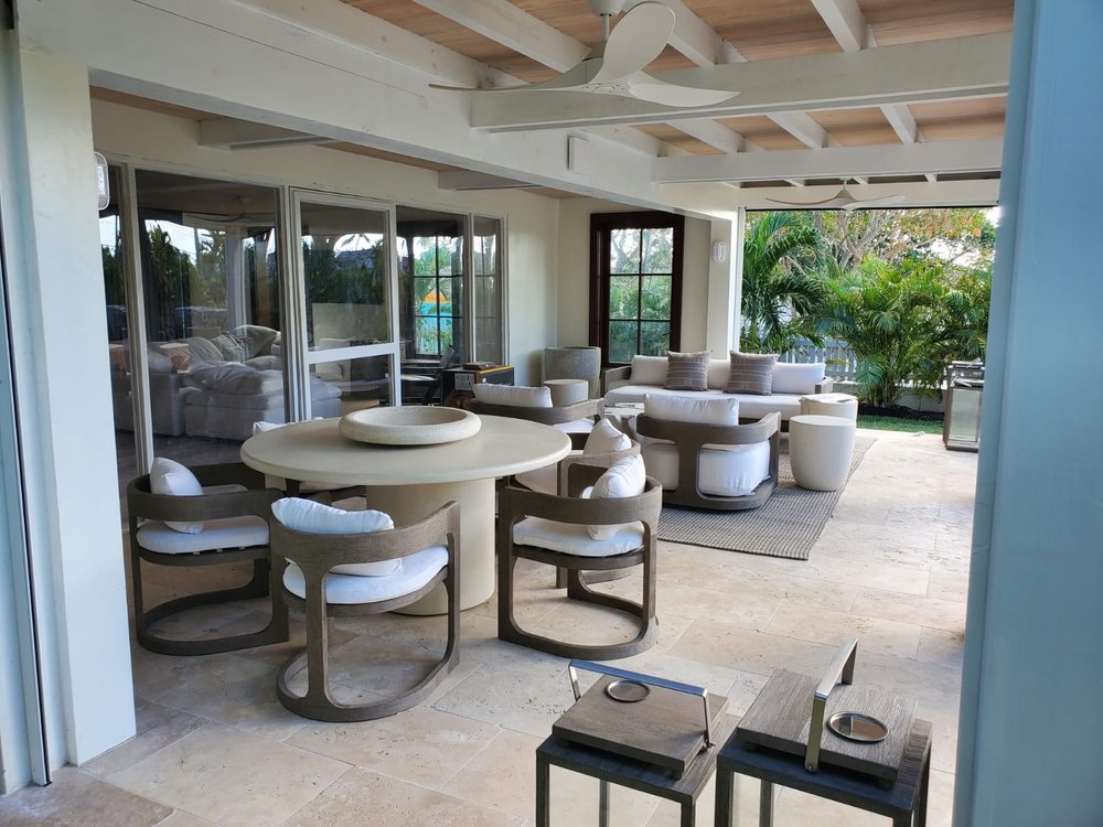 Covered outdoor dining and lounge under an exposed beam ceiling.