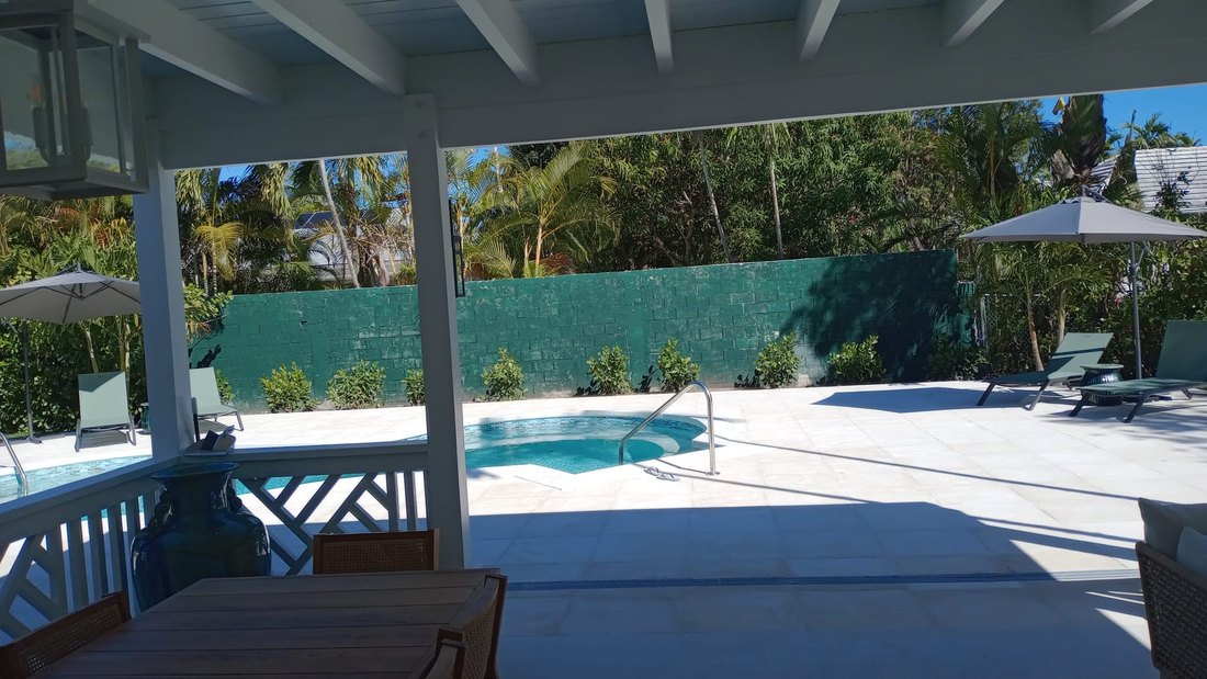 Veranda looking out across the terrace to the pool and planted boundary wall.