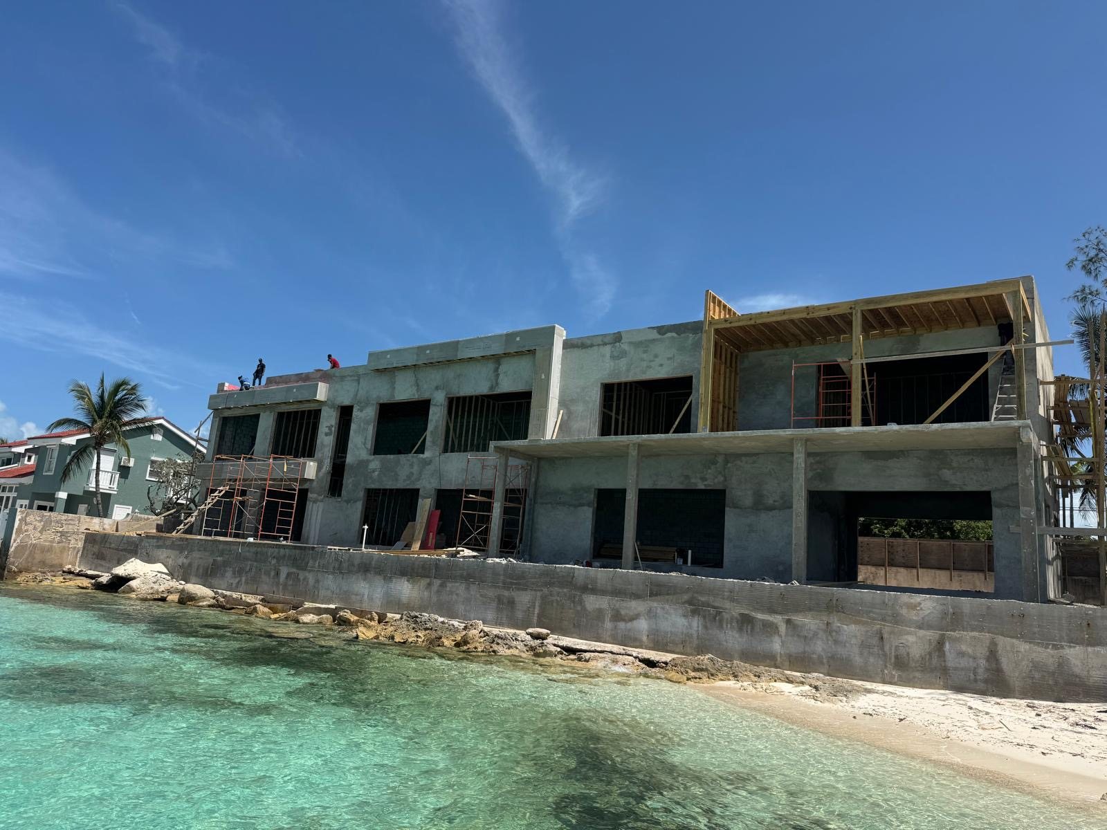 Two storey concrete beachfront residence under construction on Eastern Road, seen from the water.