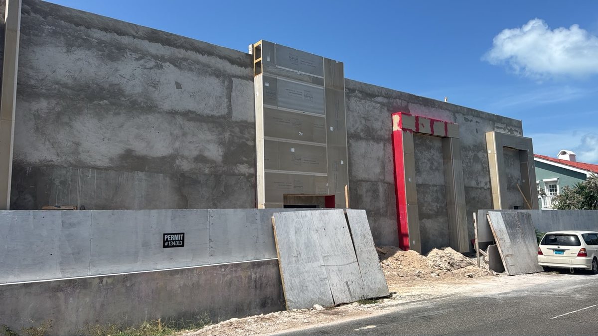 Concrete walls and framed door openings along the road frontage.
