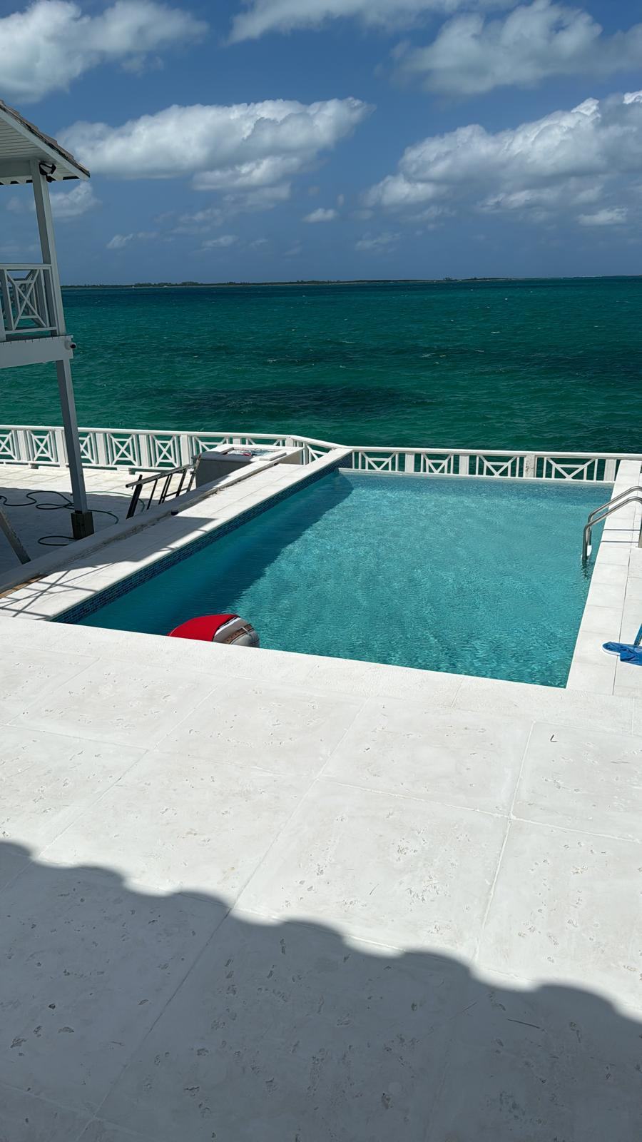 Pool set at the seawall looking out over open turquoise water.
