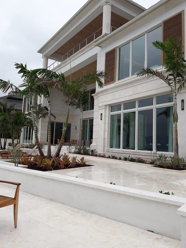Limestone clad residence at Albany with covered upper terrace, timber shutters and travertine paving.