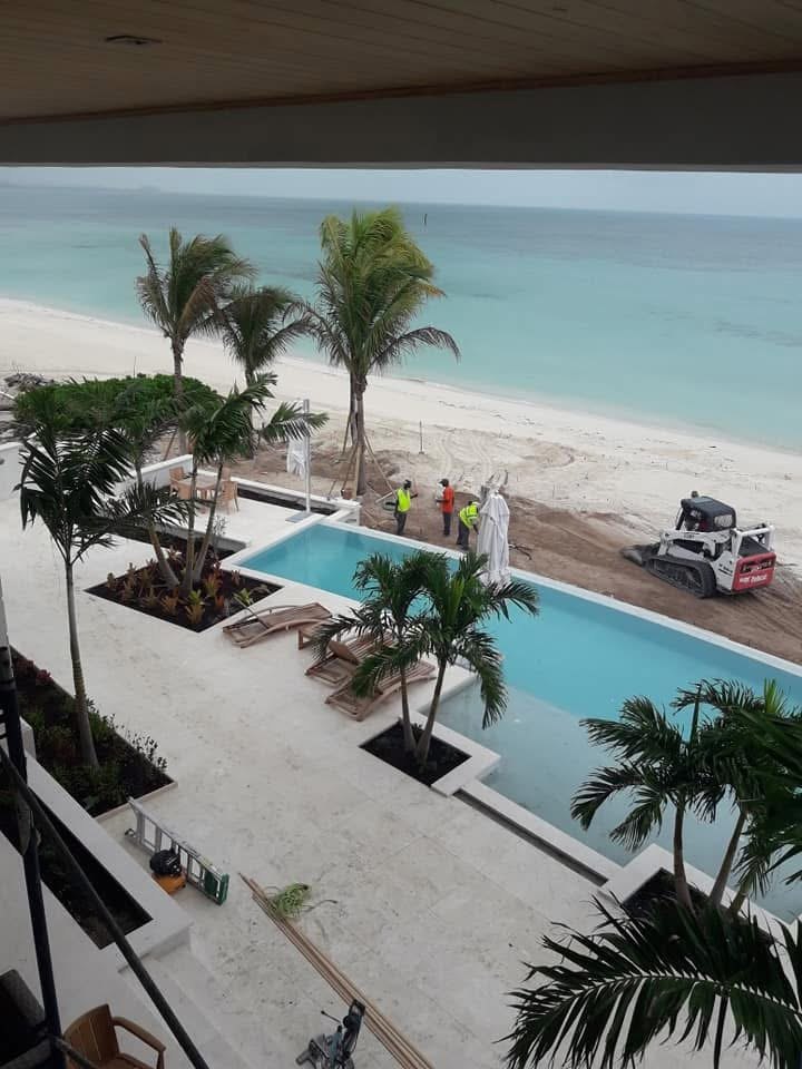 Infinity edge pool on the travertine terrace looking out over the beach and turquoise water.