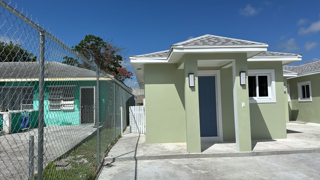 Single unit entrance with a covered portico and shingle hip roof.
