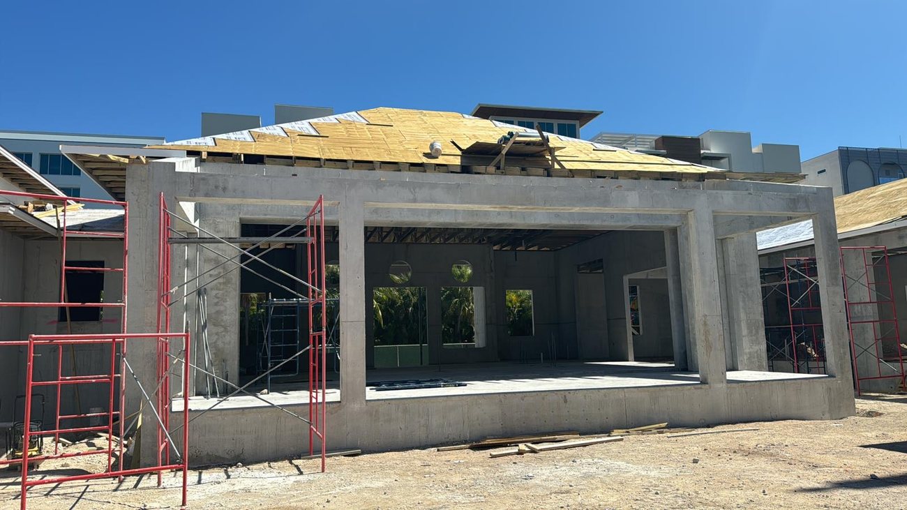Multi unit concrete structure with roof decking being installed.
