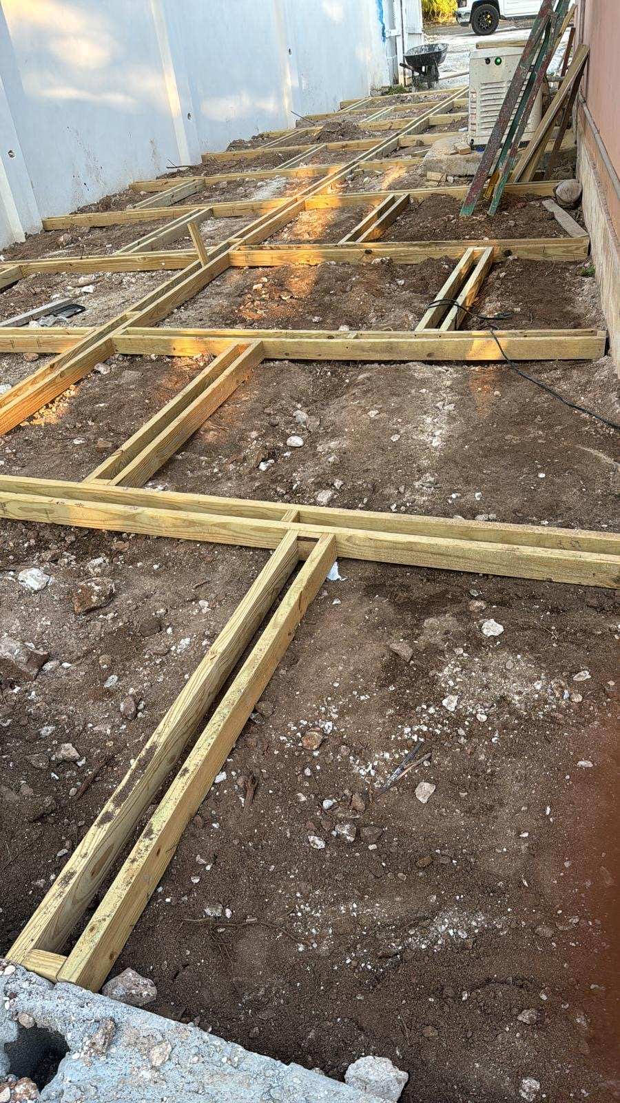 Pressure treated joists laid out and levelled for a new hardwood deck.